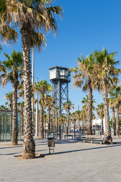 Plaça del Mar and Torre Sant Sebastia, a free-standing lattice tower with a triangular cross-section. Standing 81 meters high which is used as terminal of the Port Vell Aerial Tramway of Barcelona