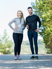 Couple training stretching after workout in nature. Young woman