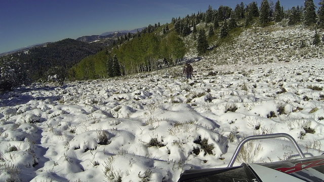 Hunter hiking up mountain in snow during deer season HD 0074