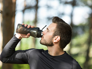 handsome man drinking water on a sunny day