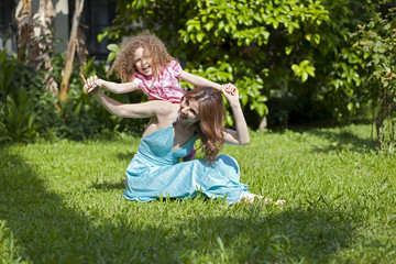 Fototapeta premium Mother and daughter are enjoying on grass at park