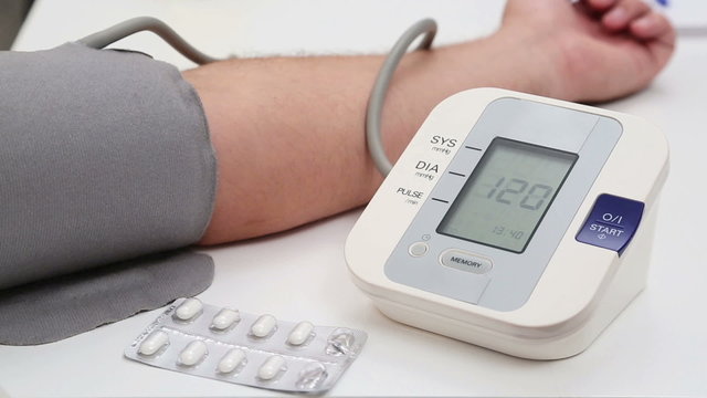 Man measuring his blood pressure at home and the results are good.
