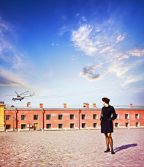 Business Woman looks at helicopter takes off on a background