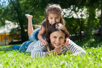 Fototapeta premium Mother and Daughter playing on Green Grass