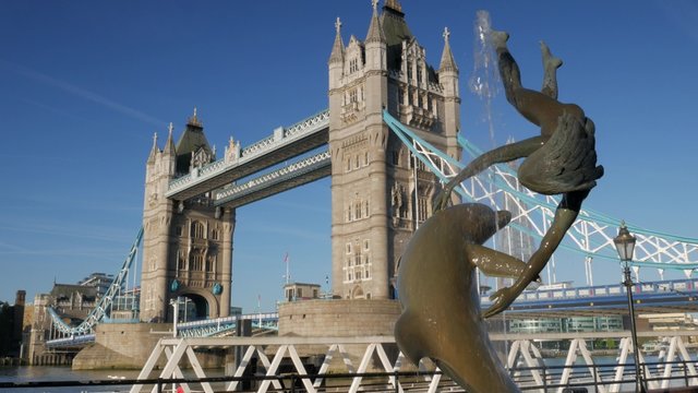 Static shot of Tower Bridge on a sunny morning. Framed by the statue of girl with dolphin and shot on 4K