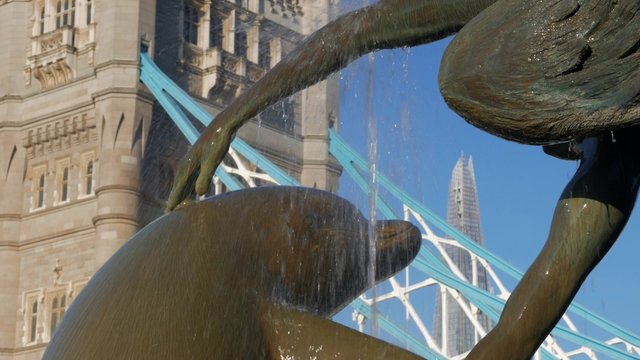 The Shard London and Tower Bridge framed inside the fountain of girl and dolphin on the banks of the River Thames. Taken on a clear sunny autumn morning in 4K