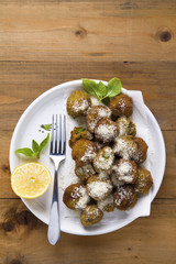 Green Meatballs in white plate on wooden table