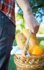 Man holding a basket with an bread on picnic