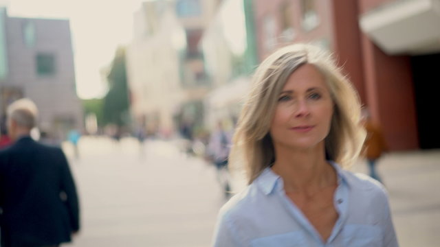 Mature woman walking confidently on a city street