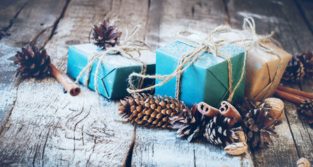 Holiday Blue Boxes with Linen Cord, Cinnamon, Pine cones, Nuts on Wooden Background. Toned