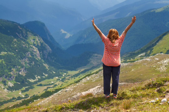 Woman with raised hands in mountains