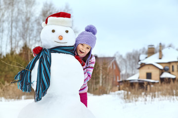 kid playing with snowman