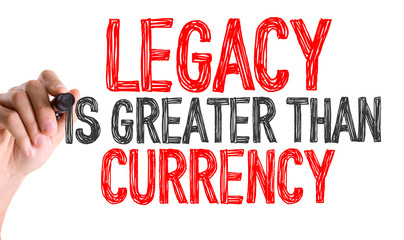 Hand with marker writing: Legacy is Greater Than Currency