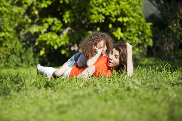 Mother and daughter are enjoying on grass at park