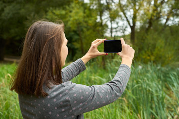 woman photographing nature in the woods