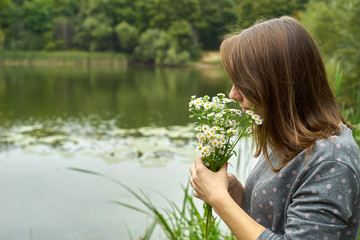 woman smelling a daisy
