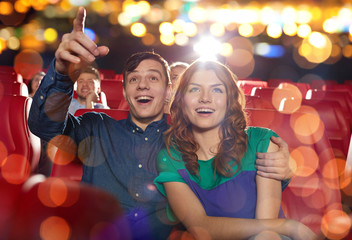 happy friends watching movie in theater
