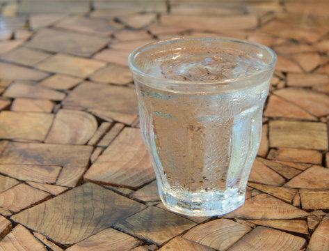 Glass cold water on wooden table.