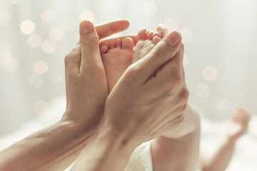 Mother touching feet of newborn