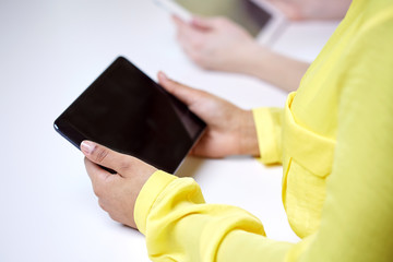 close up of female hands with tablet pc at table