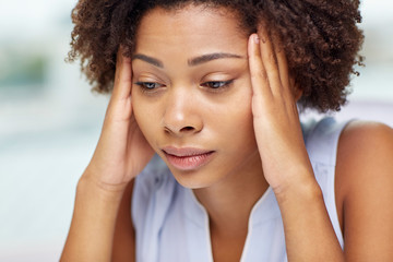 close up of african young woman touching her head