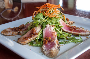 seared ahi tuna appetizer with caramelized garlic with arugula salad