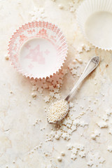 Fototapeta na wymiar Muffin cases and sugar pearls for Christmas baking