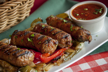 sausage appetizer with marinara dipping sauce on a bed of cartelized onions