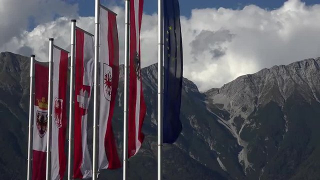 Innsbruck Austria flags in front of mountains 4K 053