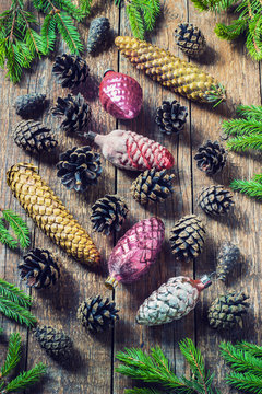 toys for the Christmas tree and pine cones on old wooden background