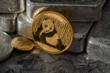 Chinese Gold Panda Coin infront of Silver Bars on Map