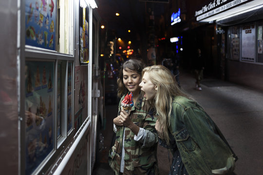 Two young women sharing an ice cream