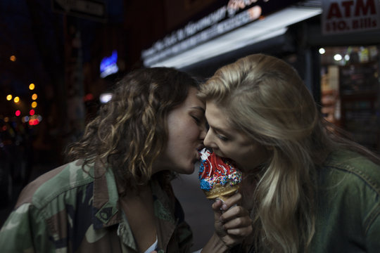 Two young women sharing an ice cream