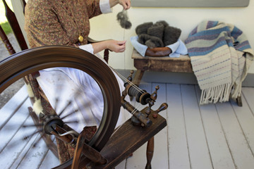 Fototapeta na wymiar Pioneer historic woman spinning wheel making yarn
