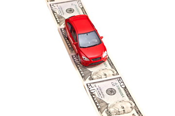 Red toy car on the money road, isolated on white
