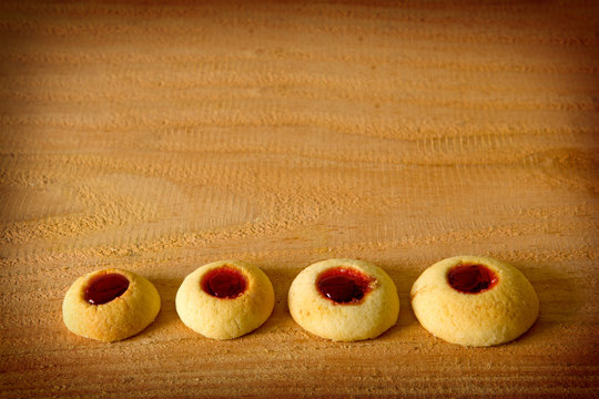 Angel Eyes biscuits with jam isolated on wood background.