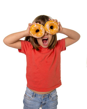 happy female child having fun playing with two sugar donuts in the eyes smiling excited