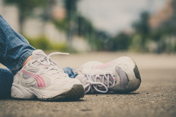 Naklejka premium youth sneakers on girl legs on road