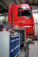 LKW-Werkstatt, rote Zugmaschine mit Fahrzeugdiagnostik