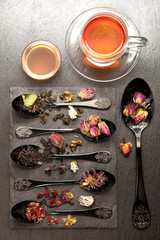 Various teas and dried herbs in a vintage spoon. Top view, vertical