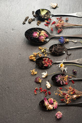 Various teas and dried herbs in a vintage spoon. Top view, vertical