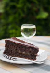 piece of chocolate cake on a white plate and a glass of white wine in an Italian café