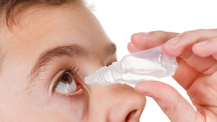 Boy applying eye drop