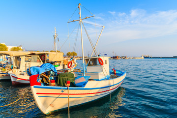 Naklejka na ściany i meble Traditional colourful Greek fishing boat in Pythagorion port at sunset time, Samos island, Greece