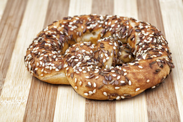 Bavarian soft pretzel with black and white linseed, broken salt pieces and cumin. Studio shot. Photographed on wooden table.