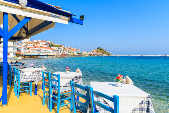 Fototapeta Tables with chairs in traditional Greek tavern in Kokkari town on coast of Samos island, Greece
