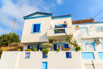 Typical white Greek house with blue windows on coast of Samos island, Greece