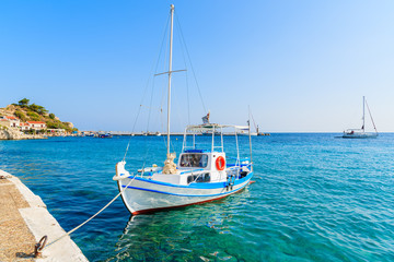 Obraz premium White and blue color Greek fishing boat mooring in Kokkari port, Samos island, Greece