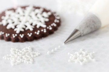 Obraz na płótnie Canvas Decorating cookies with royal icing snow flakes.