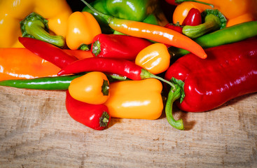 Knackiges Würzgemüse auf Holztisch - Chili, Paprika und Peperoni